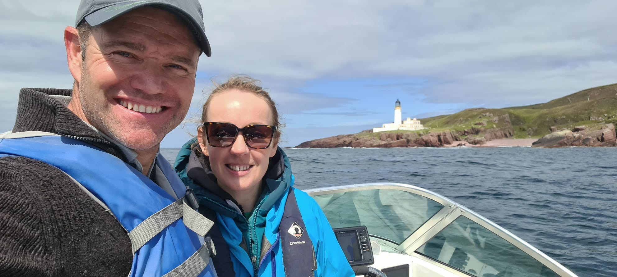 Cornelius and Hannah on the boat with Rua Reidh Lighthouse near Gairloch in the background